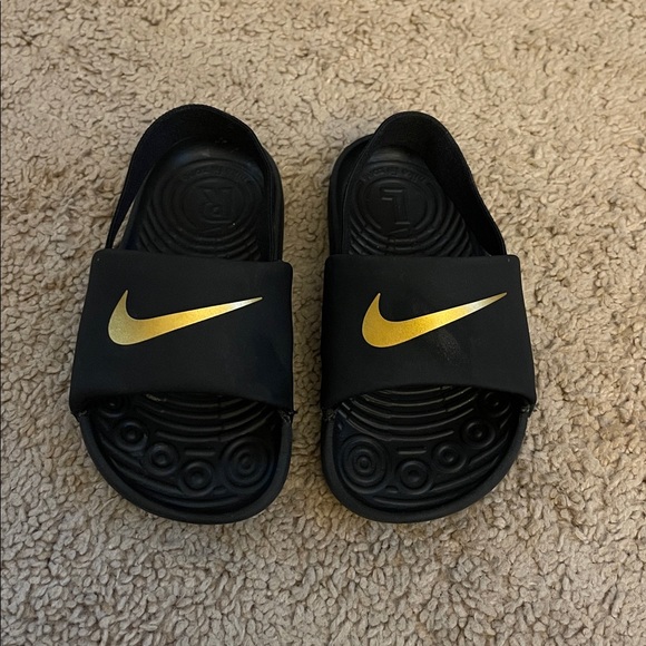 Kids Nike Black Slides with Gold Swoosh. ⭐️Size 8 BUT FITS LIKE A 7.⭐️ - Picture 1 of 3